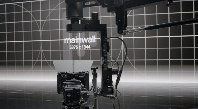 Robotic camera setup in a studio environment displaying a digital grid background with the text "mainwall 5376 x 1344," highlighting advanced technology in film production and visual effects.