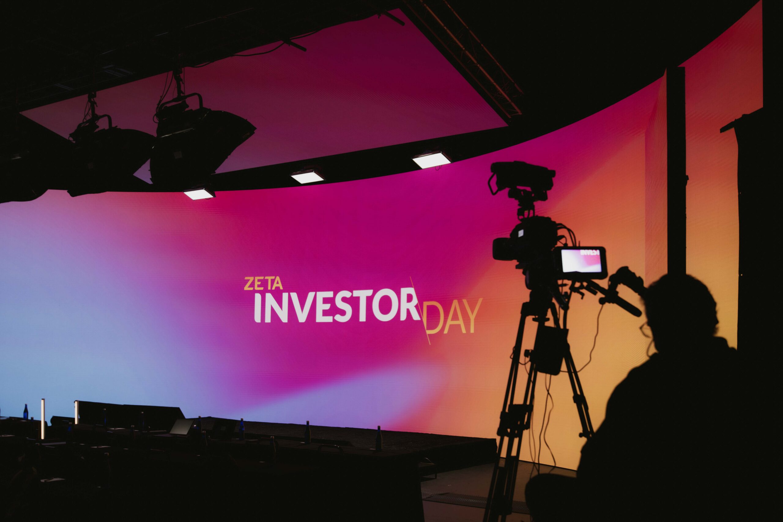 Zeta Investor Day stage setup with colorful backdrop and camera equipment, showcasing a professional event environment for investors.